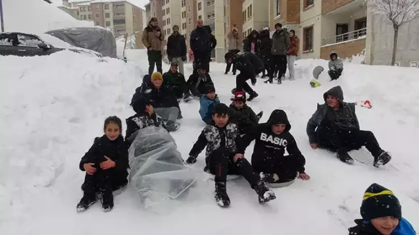 Yüksekova'da tepsiler kızak oldu, karlı yamaçlar oyun alanına dönüştü