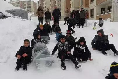 Yüksekova'da tepsiler kızak oldu, karlı yamaçlar oyun alanına dönüştü